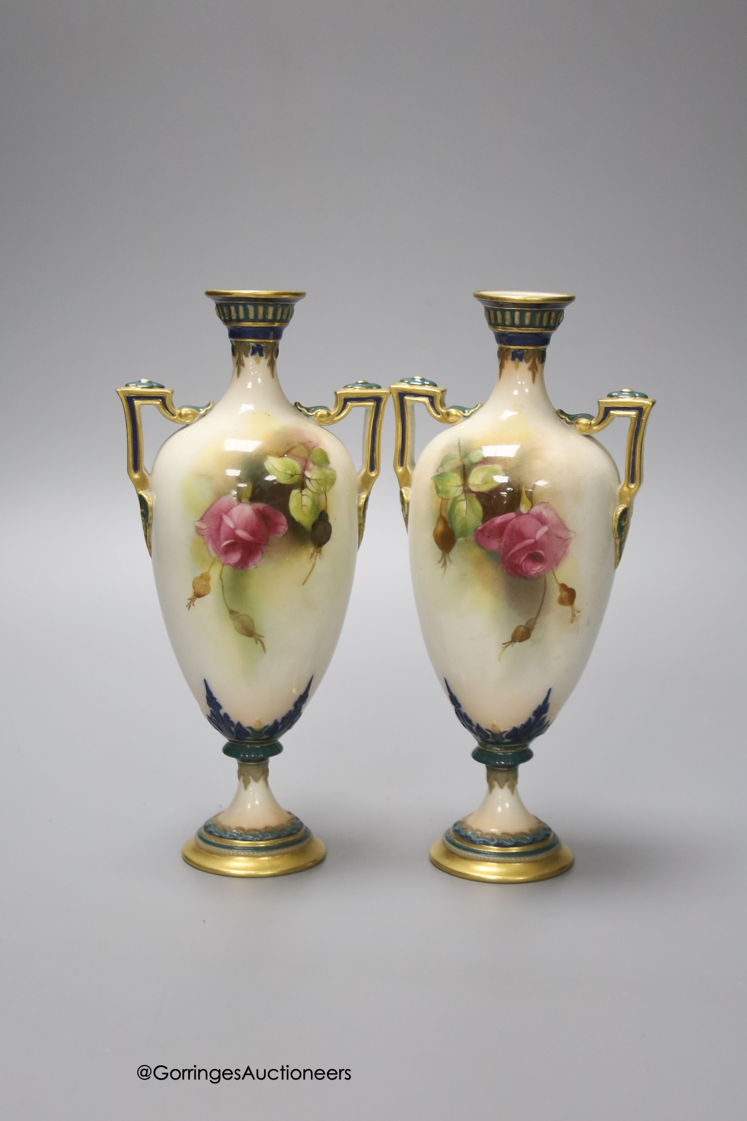 A pair of Royal Worcester two handled vases, decorated with roses, unsigned, 18cm (one a.f.)